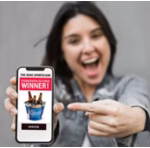 Woman holding cellphone displaying Winner scratch-off card reveal.